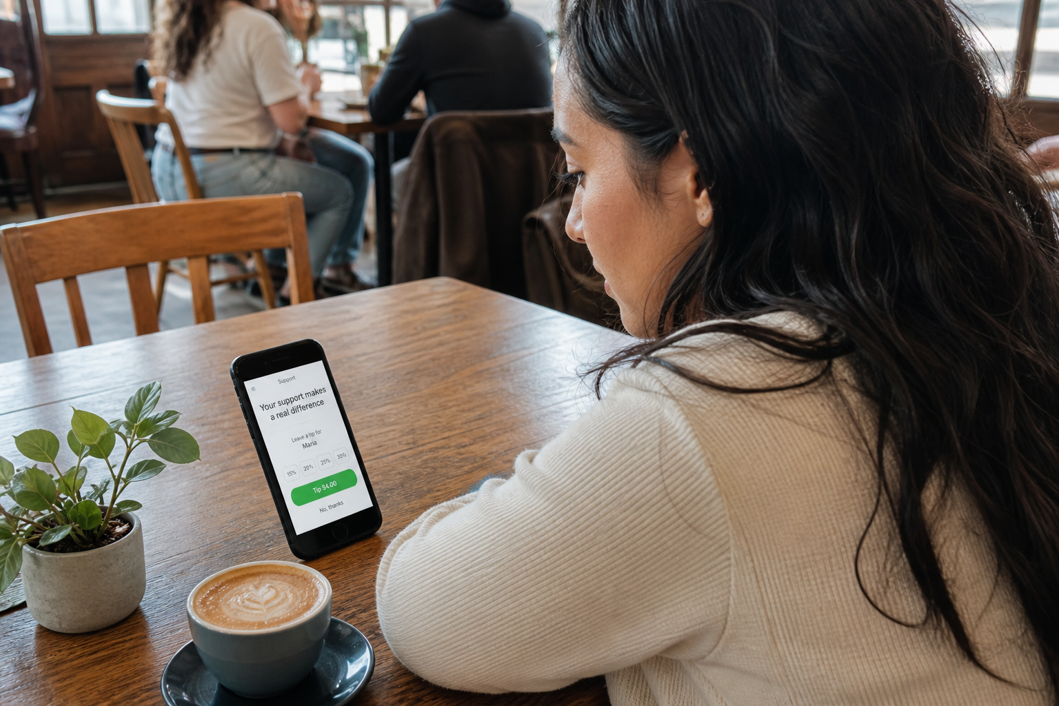 Creadora viendo su página FWDLink en el celular en un café con luz natural